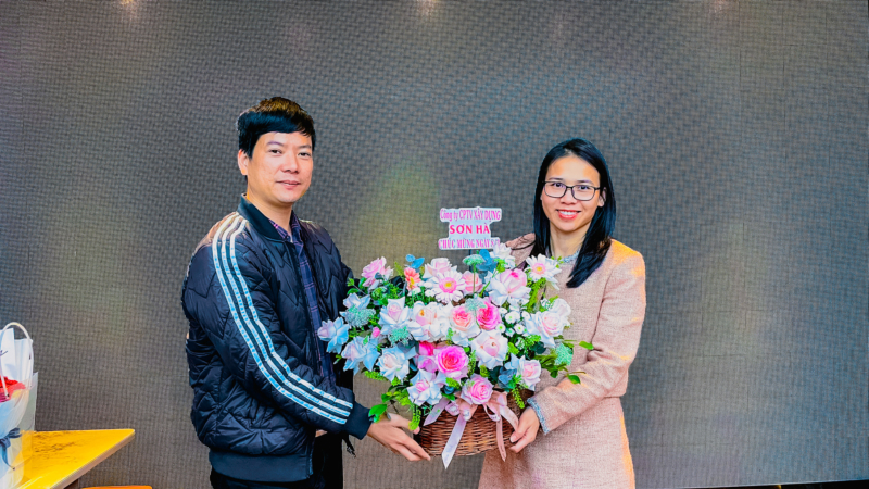 Bà Nguyễn Thị Nhung đại diện cho các nữ cán bộ nhận bó hoa tươi thắm từ Ban giám đốc