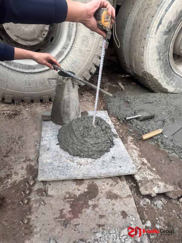 Những Lưu Ý Quan Trọng Khi Thi Công Móng - Kiến Thức Chủ Nhà Nhất Định Phải Biết 2 Công nhân đang thí nghiệm kiểm tra độ sụt bê tông